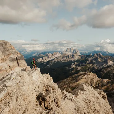 Hiker admiring a sweeping mountain view in the Dolomites, Italian Alps. Ph Alex Moling